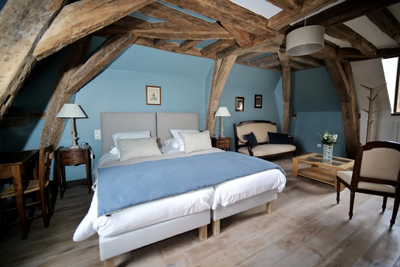 Vue de la chambre bleue avec fauteuil et éclairage doux Vue de la chambre bleue avec fauteuil et éclairage doux